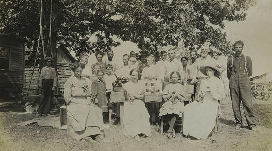 Group photo beside a table with tomatoes, 1912; Mabelvale Home Demonstration Club Records MC1640 © Pryor Center for Arkansas Oral and Visual History, University of Arkansas